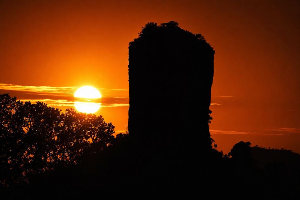 Formação rochosa em silhueta no pôr do sol do cerrado