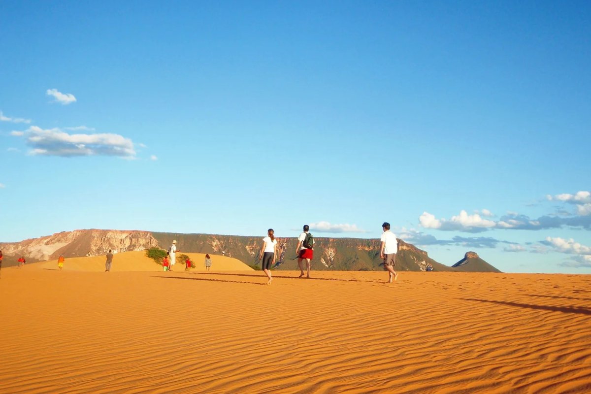 Grupo de viajantes caminhando nas dunas de areia de quartzo do Jalapão