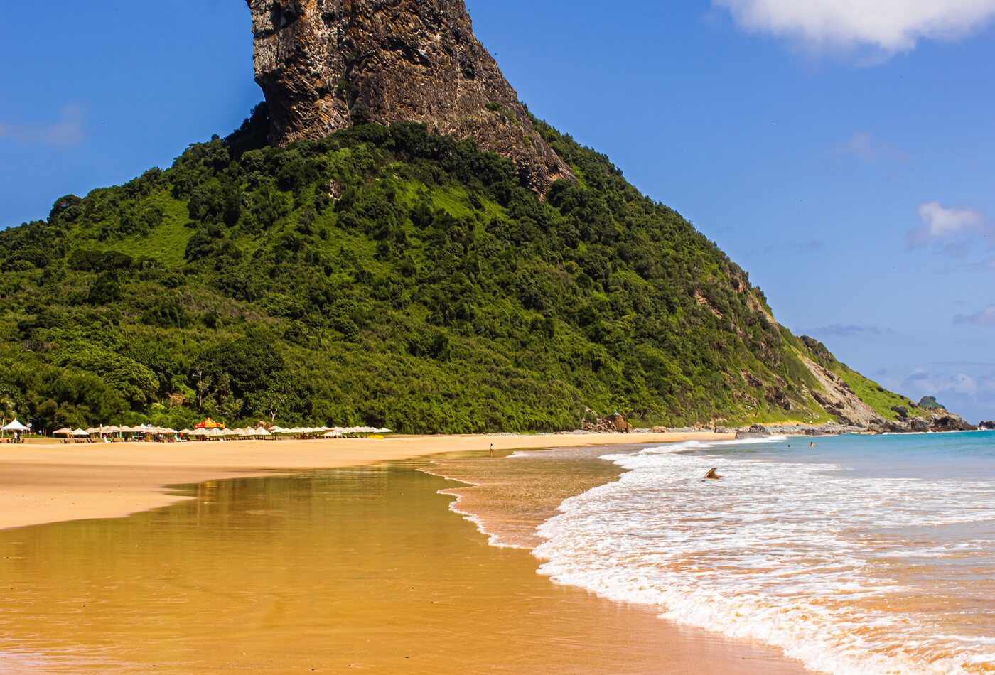 Areia dourada e forma&ccedil;&atilde;o rochosa numa praia de Fernando de Noronha