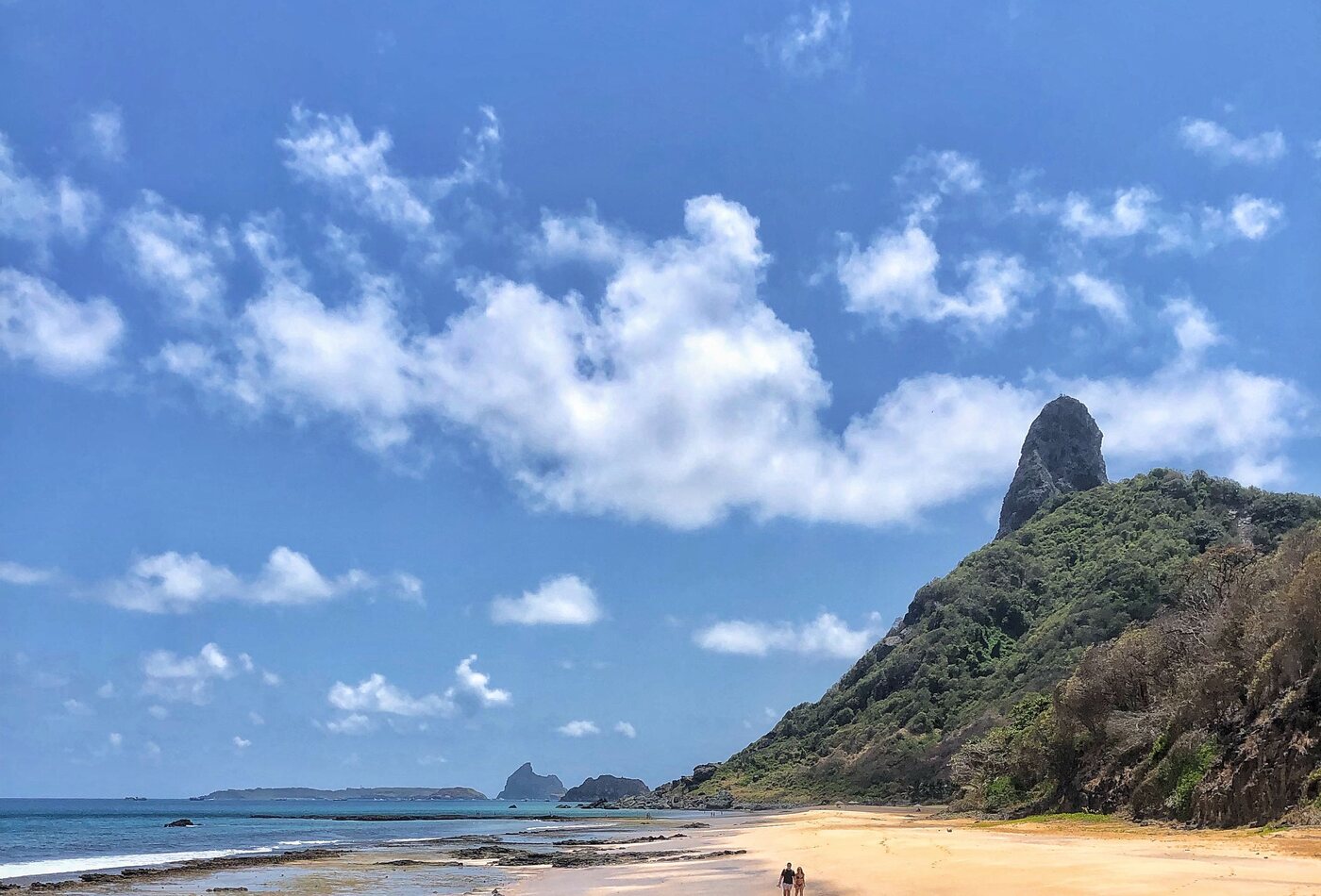 Praia de areia clara com o Morro do Pico ao fundo em Fernando de Noronha