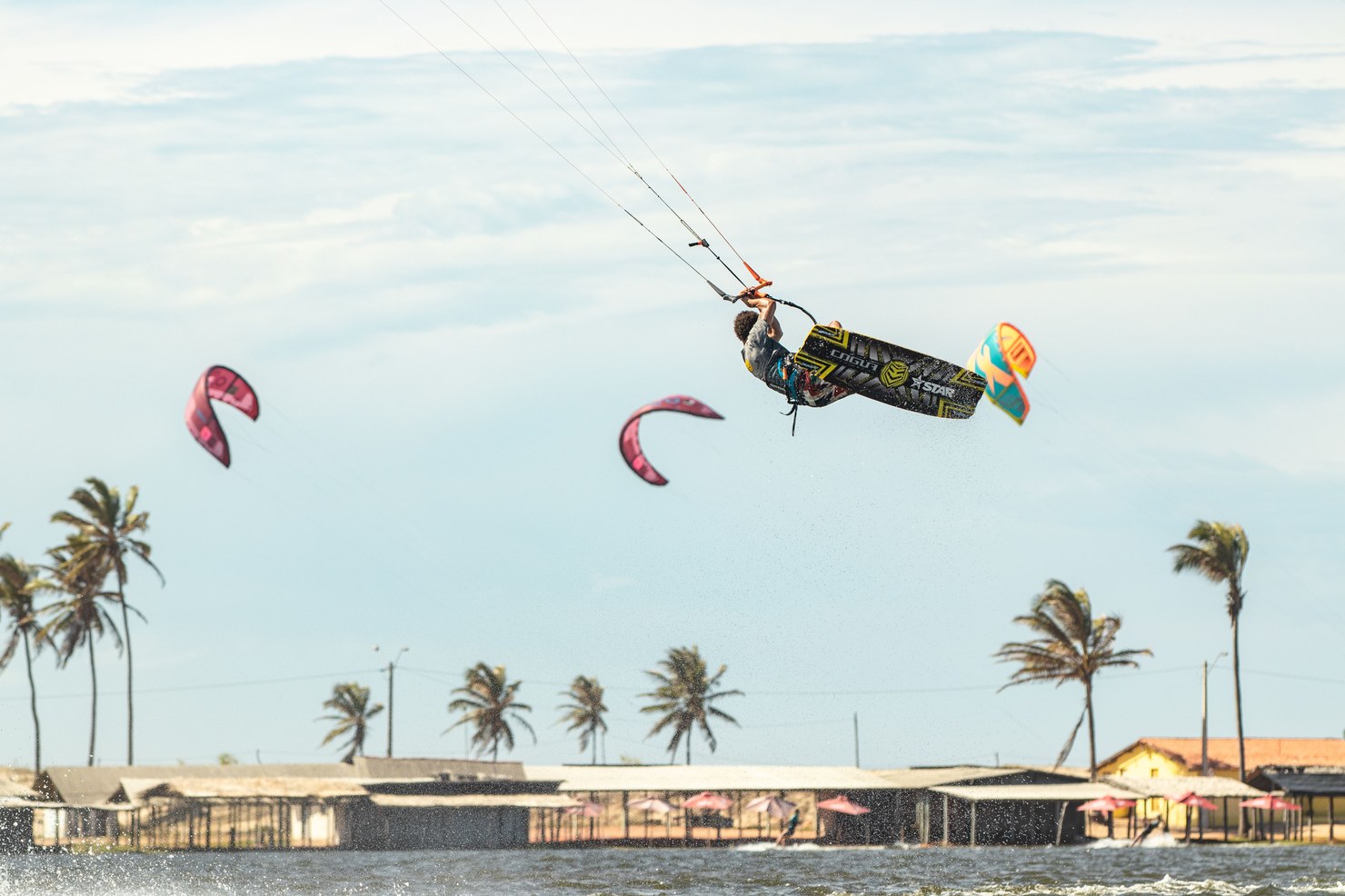 Kitesurfe em manobra aérea sobre os coqueiros em Jericoacoara