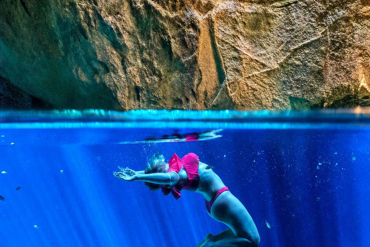 Flutuação em nascente de água azul cristalina com paredes de rocha calcária acima da linha d'água, Chapada das Mesas