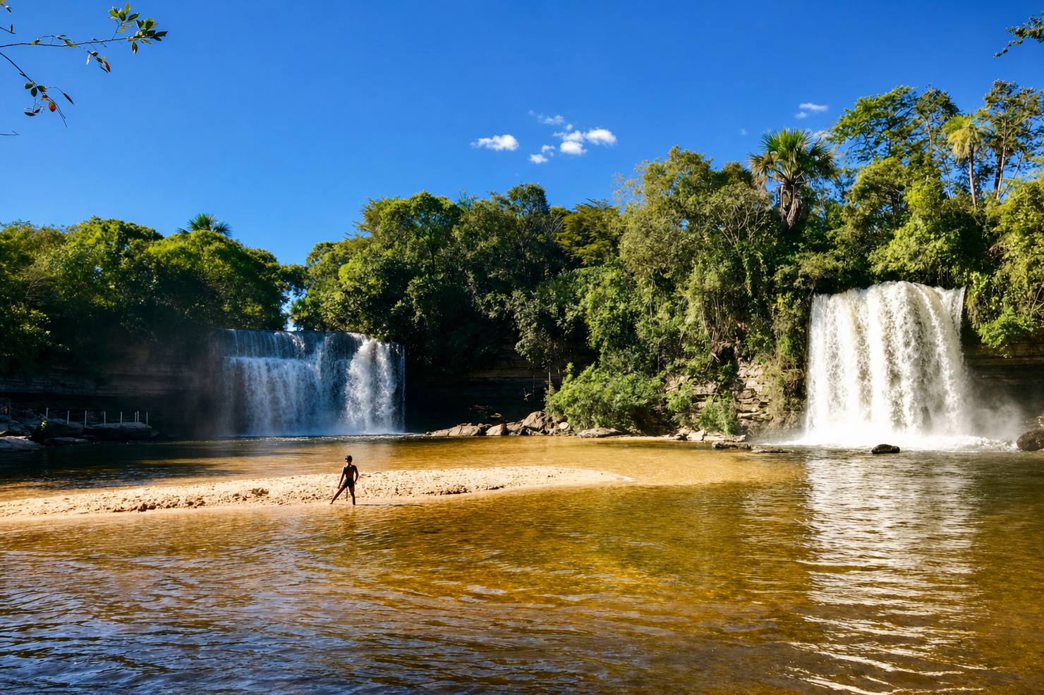 Duas quedas d'água lado a lado formando uma piscina natural com faixa de areia, nas Cachoeiras Gêmeas do Itapecuru