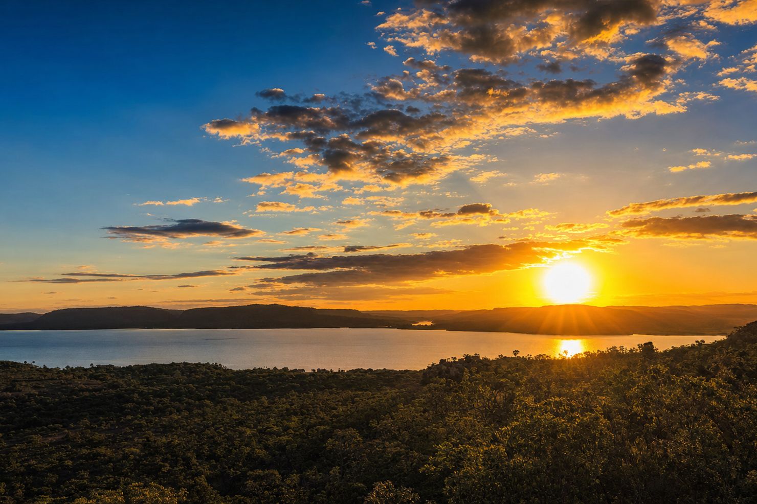 Pôr do sol panorâmico sobre o cerrado e o lago, visto do Mirante do Cerrado na Chapada das Mesas