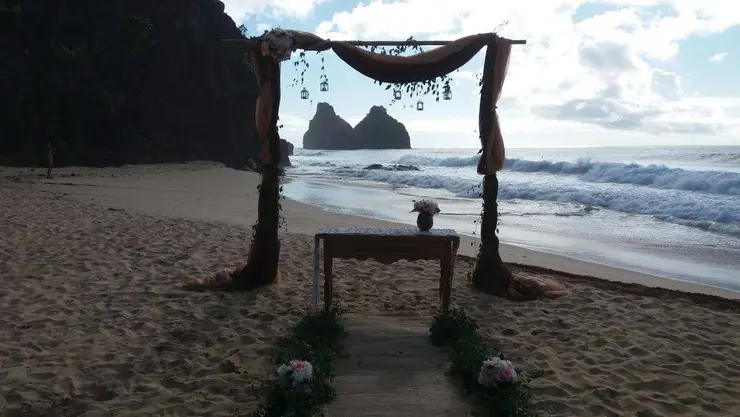 Altar de casamento montado na praia com o Morro Dois Irmãos ao fundo, em Fernando de Noronha