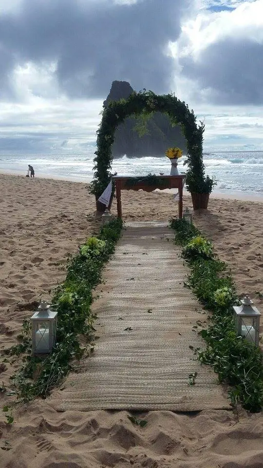 Corredor de cerimônia na areia levando ao altar decorado, em Fernando de Noronha