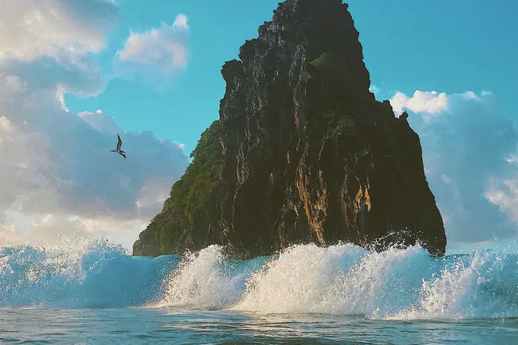 Ondas do oceano quebrando contra formação rochosa em Fernando de Noronha