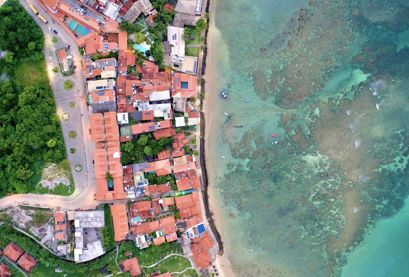Vista de cima dos telhados da vila de Morro de São Paulo e do recife de coral junto à praia