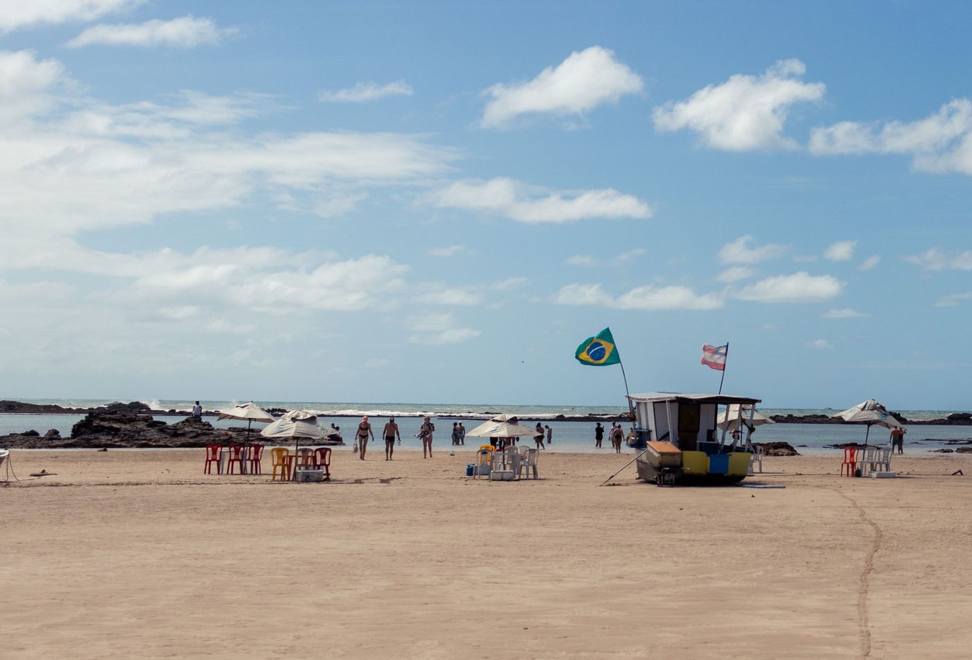 Barraca de praia com cadeiras e guarda-sóis na areia em Morro de São Paulo