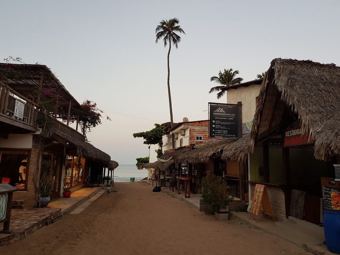 Rua de areia da vila de Jericoacoara, com pousadas e restaurantes de palha