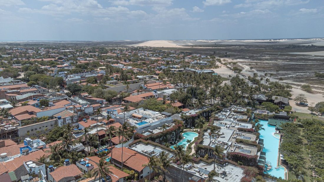 Vista aérea da vila de Jericoacoara com o campo de dunas ao fundo