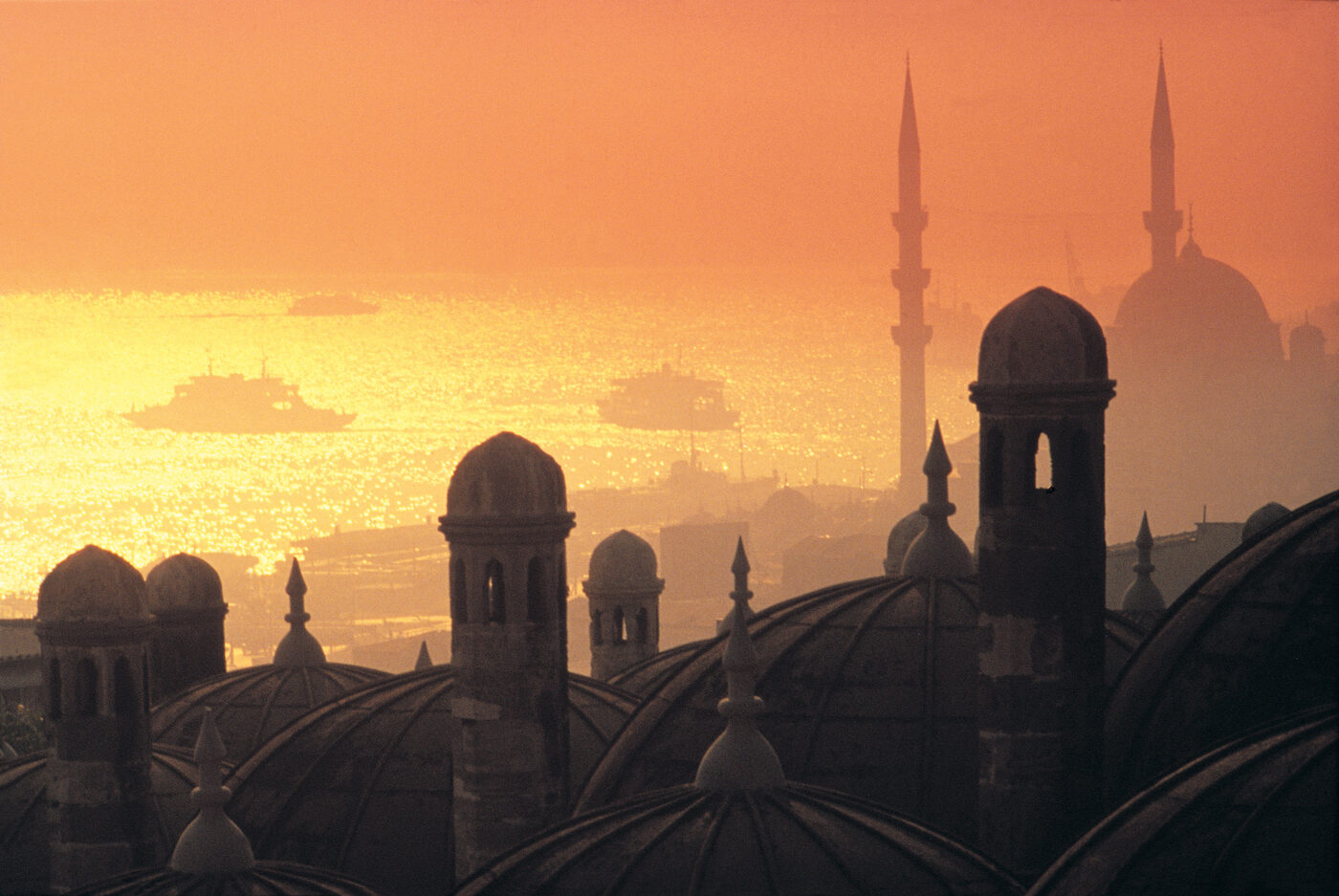 Cupulas e minaretes de Istambul recortados contra o por do sol sobre o Bosforo