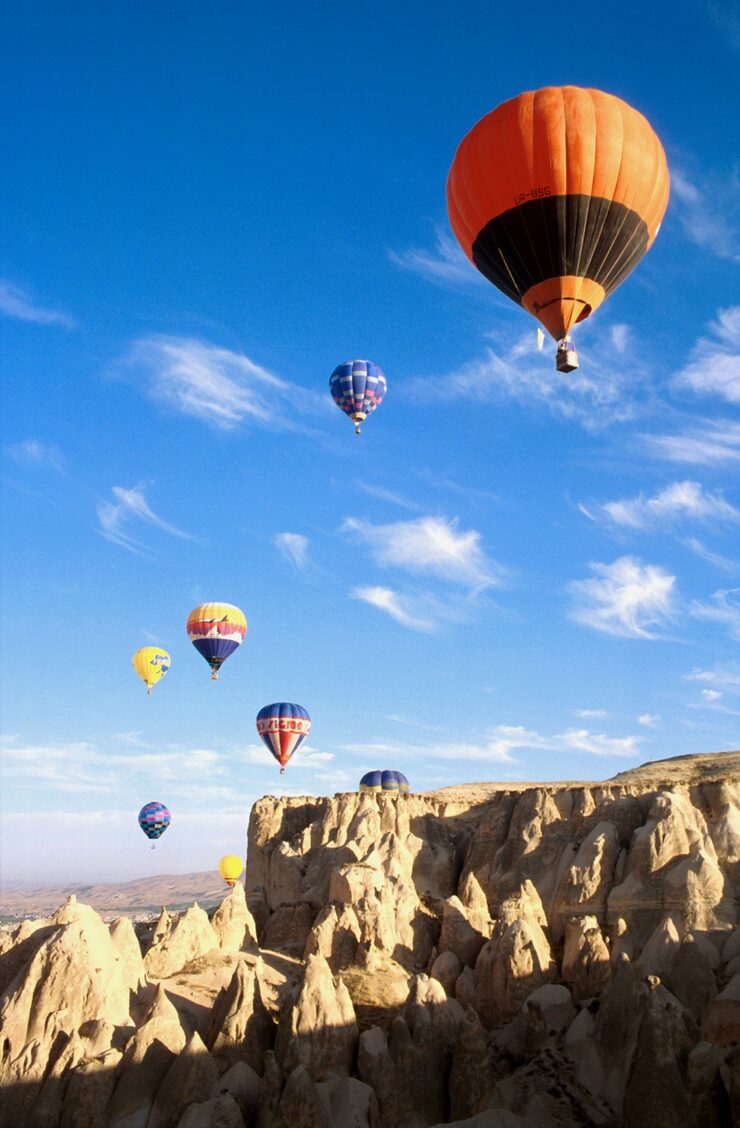 Baloes coloridos sobrevoando os vales da Capadocia ao amanhecer
